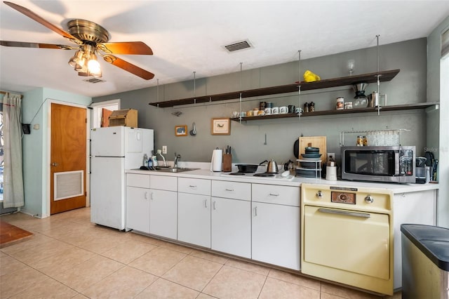 535 NE 9th Ave, Gainesville, FL 32601 - kitchen featuring stainless steel microwave, a sink, freestanding refrigerator, ceiling fan, and light countertops