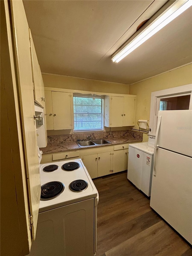 kitchen featuring white appliances, a sink, washer / clothes dryer, white cabinetry, and dark wood finished floors