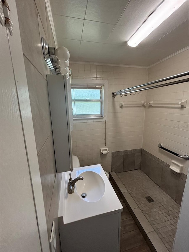 bathroom featuring a stall shower, vanity, and crown molding