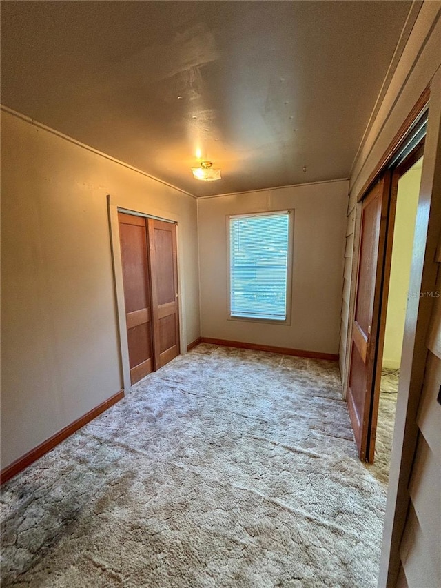 unfurnished bedroom featuring carpet and baseboards
