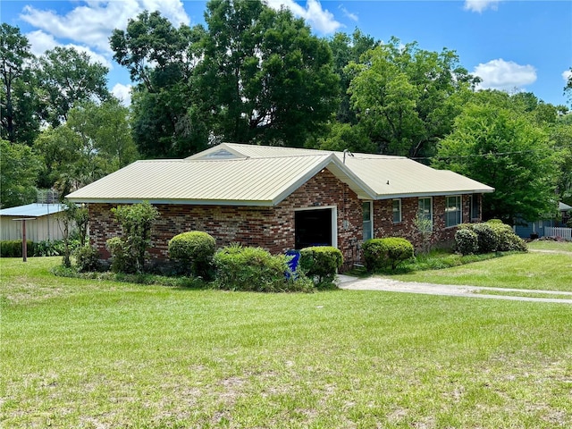 ranch-style home featuring a front lawn and brick siding