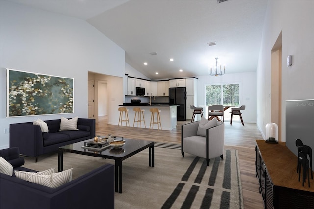 living room featuring a chandelier, light wood-type flooring, high vaulted ceiling, baseboards, and recessed lighting