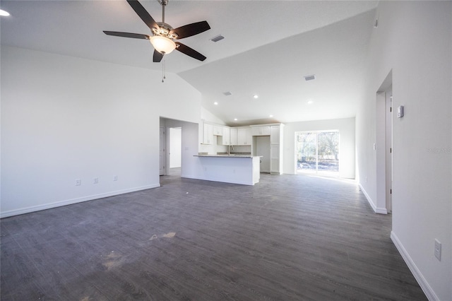 unfurnished living room with a ceiling fan, recessed lighting, baseboards, dark wood finished floors, and high vaulted ceiling