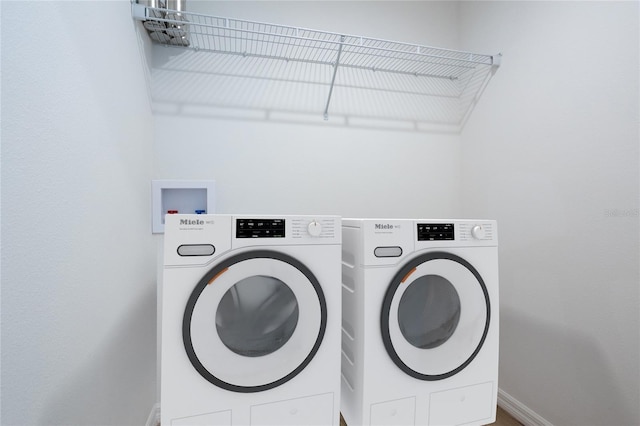laundry room with washer and clothes dryer and baseboards