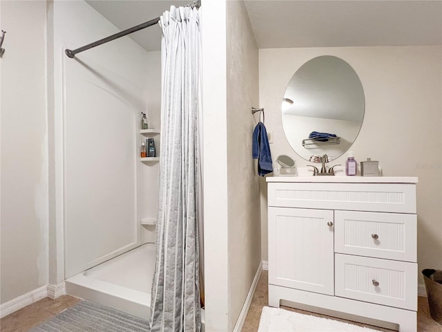 bathroom featuring a stall shower, vanity, and baseboards