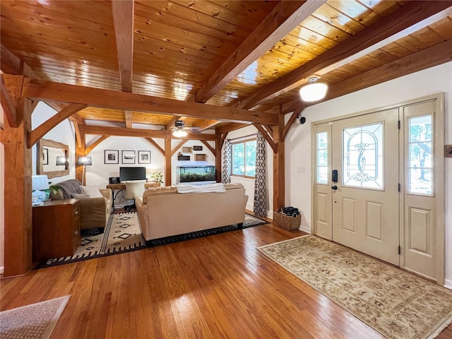 entryway featuring wood finished floors, a ceiling fan, beamed ceiling, wooden ceiling, and baseboards