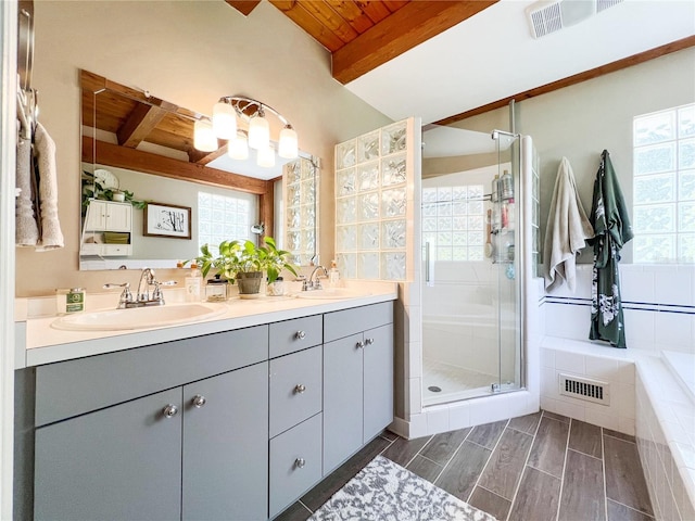 bathroom featuring wood ceiling, beamed ceiling, a shower stall, double vanity, and tiled tub
