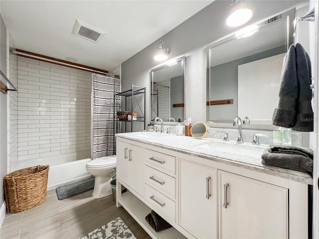 full bathroom featuring double vanity, toilet, wood finished floors, and shower / bath combo