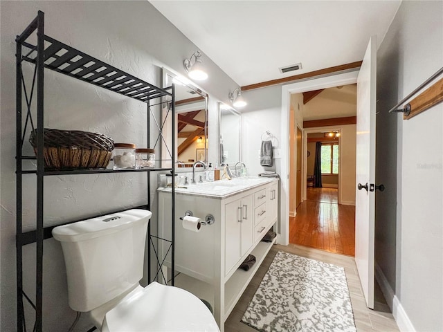 bathroom featuring wood finished floors, vanity, and a textured wall