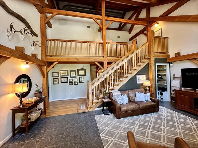 living room with stairway, a towering ceiling, and baseboards