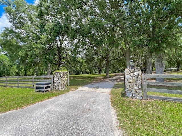 view of asphalt driveway featuring a gated entry