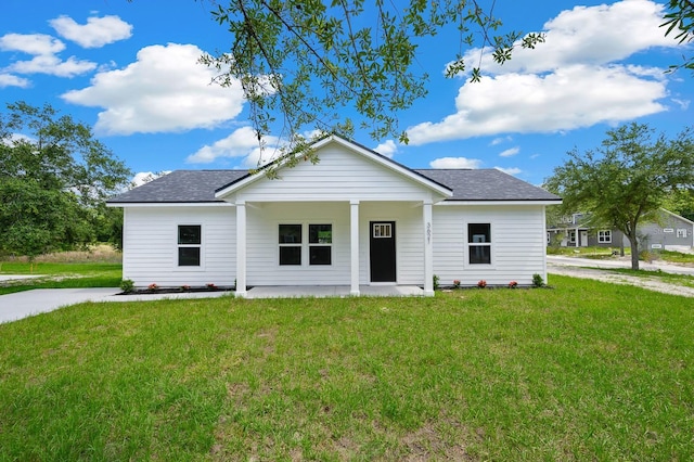 view of front of property with a front yard, roof with shingles, and a porch