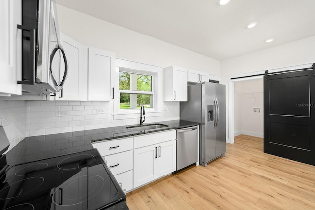 kitchen featuring stainless steel appliances, a sink, white cabinets, and recessed lighting