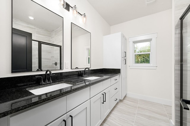 full bath featuring a stall shower, baseboards, and double vanity