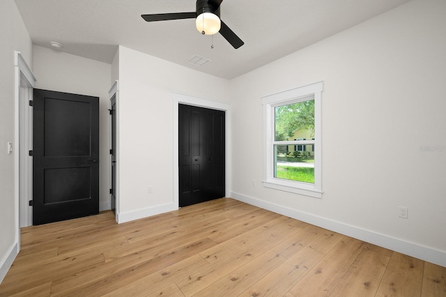 unfurnished bedroom with light wood-style floors, baseboards, and a closet