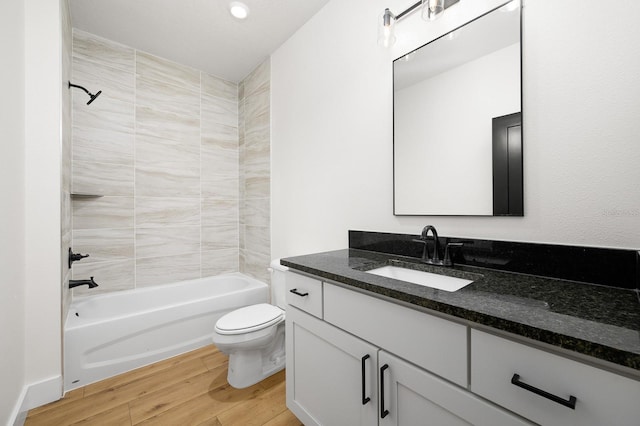 full bath with wood finished floors, toilet, vanity, and washtub / shower combination