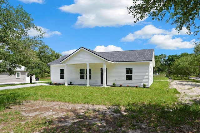 view of front facade with roof with shingles, a front yard, and a porch