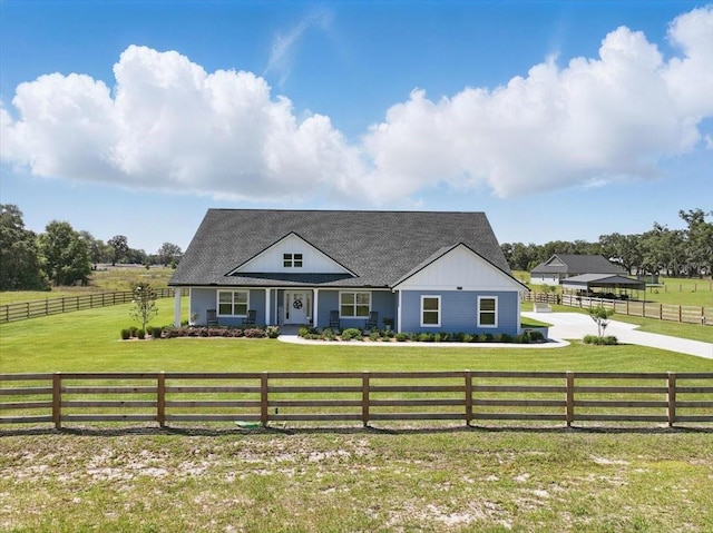 view of front of house with a shingled roof, a view of countryside, and board and batten siding