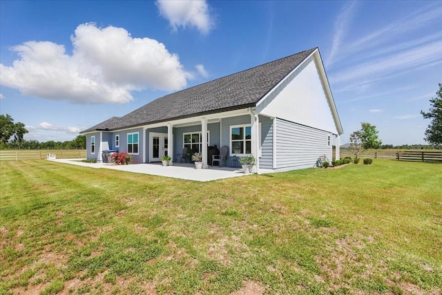 rear view of house featuring a patio and roof with shingles