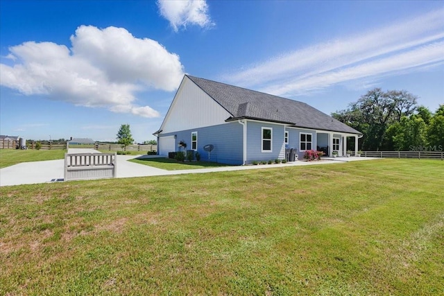 back of house with an attached garage, concrete driveway, and a patio