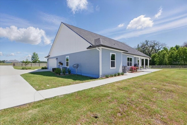 view of side of property with an attached garage and concrete driveway