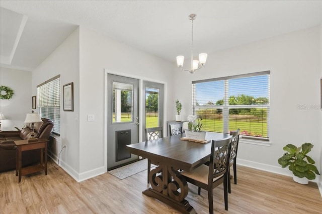 dining room with baseboards, light wood-style flooring, and a chandelier