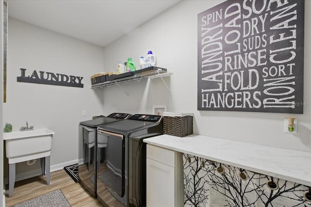 laundry area featuring separate washer and dryer, light wood finished floors, and baseboards