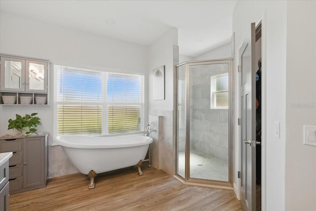 bathroom featuring a shower stall, a freestanding bath, wood finished floors, and vanity