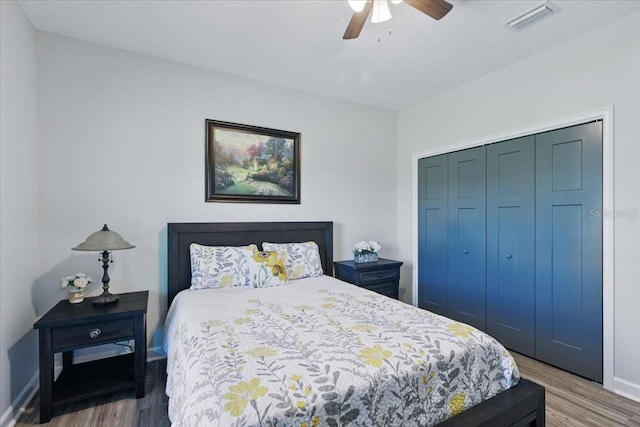 bedroom with wood finished floors, a closet, a ceiling fan, and baseboards