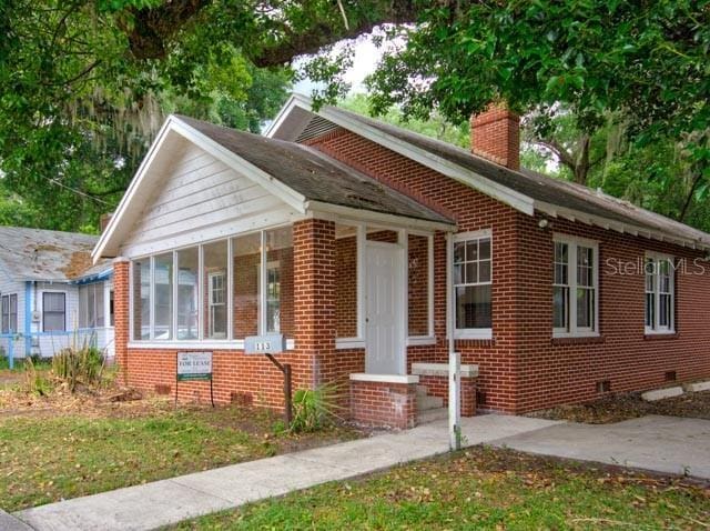 113 NW 11th St Unit 1/2, Gainesville, FL 32601 - bungalow with brick siding, crawl space, and a sunroom