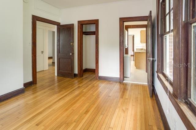 113 NW 11th St Unit 1/2, Gainesville, FL 32601 - unfurnished bedroom featuring light wood finished floors, baseboards, and a closet
