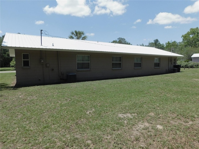 721 Town Ct Unit A & B, Bronson, FL 32621 - back of house featuring concrete block siding, a lawn, central air condition unit, and metal roof