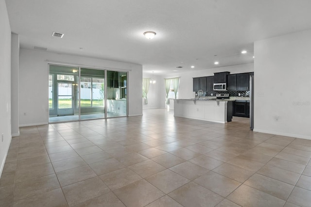 4261 SW 62nd Loop, Ocala, FL 34474 - unfurnished living room featuring light tile patterned floors, recessed lighting, and baseboards