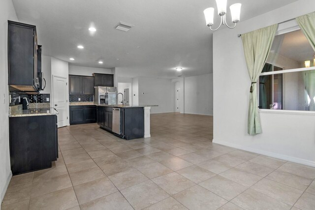 4261 SW 62nd Loop, Ocala, FL 34474 - kitchen featuring stainless steel appliances, open floor plan, tasteful backsplash, a chandelier, and light tile patterned floors
