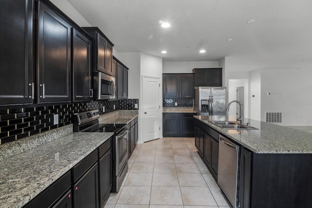 4261 SW 62nd Loop, Ocala, FL 34474 - kitchen with appliances with stainless steel finishes, a sink, decorative backsplash, light tile patterned floors, and stone counters