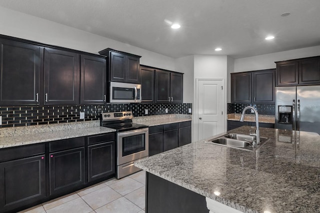 4261 SW 62nd Loop, Ocala, FL 34474 - kitchen with stainless steel appliances, a sink, backsplash, light tile patterned floors, and light stone countertops