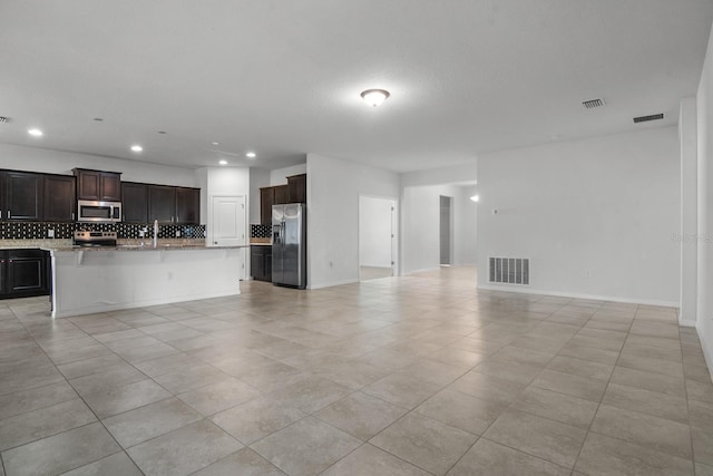 4261 SW 62nd Loop, Ocala, FL 34474 - unfurnished living room featuring light tile patterned floors, recessed lighting, a sink, and baseboards