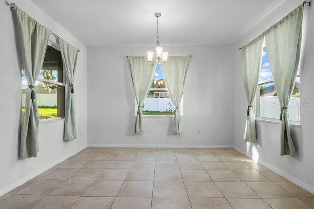 4261 SW 62nd Loop, Ocala, FL 34474 - unfurnished dining area featuring a chandelier, light tile patterned floors, and baseboards