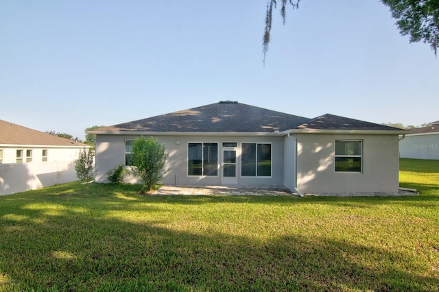 4261 SW 62nd Loop, Ocala, FL 34474 - rear view of house with stucco siding, a lawn, and a shingled roof