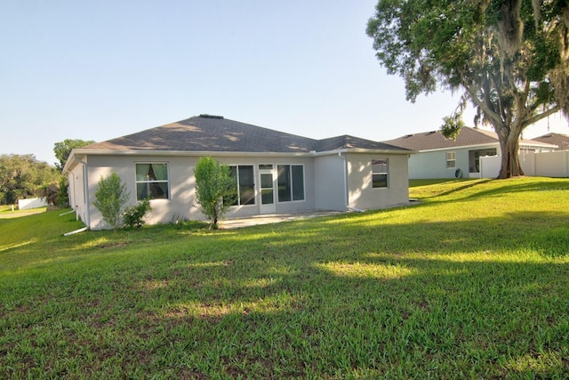 4261 SW 62nd Loop, Ocala, FL 34474 - rear view of property with stucco siding and a yard