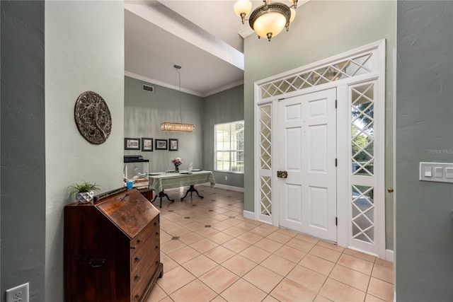 5802 SW 89th Ter, Gainesville, FL 32608 - foyer featuring crown molding, light tile patterned floors, baseboards, high vaulted ceiling, and a chandelier