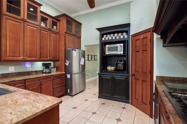 5802 SW 89th Ter, Gainesville, FL 32608 - kitchen featuring stainless steel appliances, ornamental molding, brown cabinetry, and dark stone counters