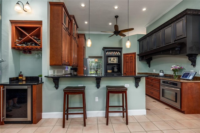 5802 SW 89th Ter, Gainesville, FL 32608 - kitchen with appliances with stainless steel finishes, beverage cooler, ornamental molding, a peninsula, and ceiling fan