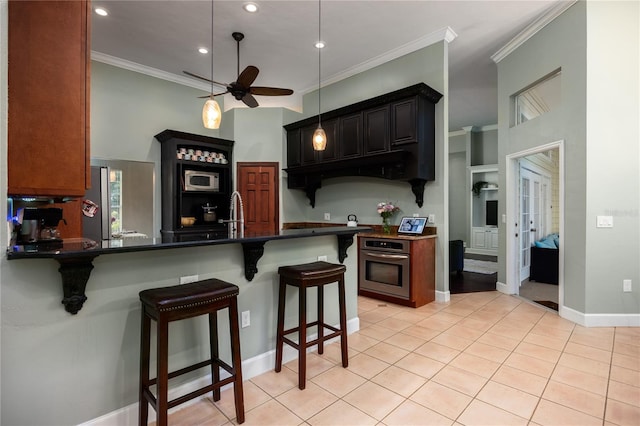 5802 SW 89th Ter, Gainesville, FL 32608 - kitchen featuring stainless steel oven, a ceiling fan, under cabinet range hood, dark countertops, and a breakfast bar area