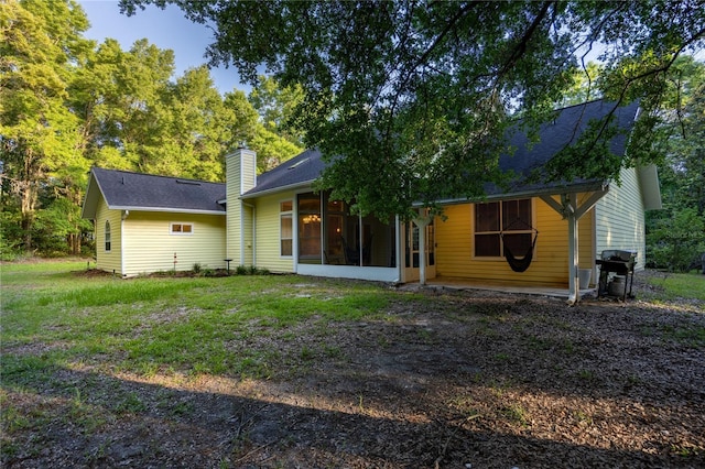 5802 SW 89th Ter, Gainesville, FL 32608 - rear view of property with a sunroom, a chimney, and roof with shingles