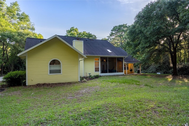 5802 SW 89th Ter, Gainesville, FL 32608 - back of house with a chimney, a sunroom, and a yard