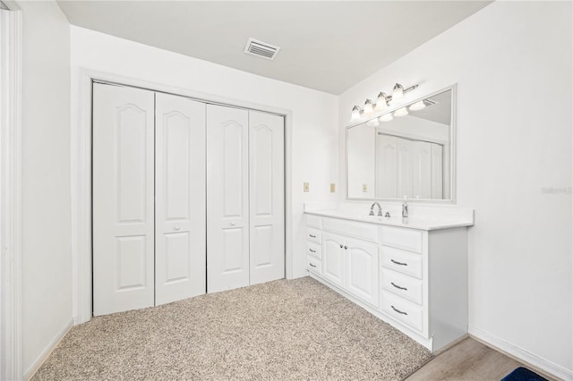 8968 122nd St, Live Oak, FL 32060 - bathroom with vanity, a closet, baseboards, and carpet flooring