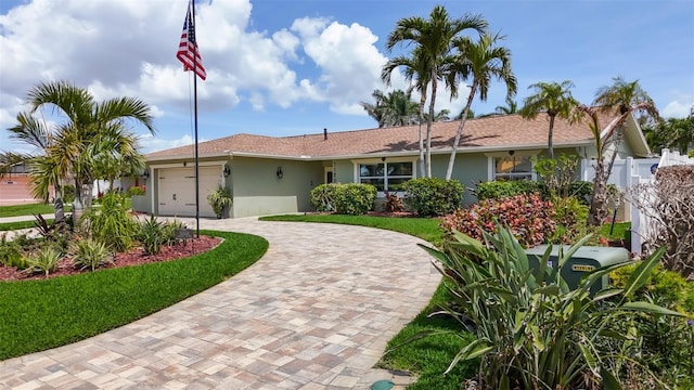 1120 81st St S, Saint Petersburg, FL 33707 - ranch-style house featuring stucco siding, decorative driveway, a garage, and fence