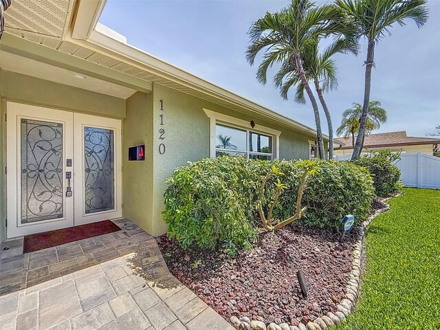 1120 81st St S, Saint Petersburg, FL 33707 - doorway to property featuring stucco siding and fence