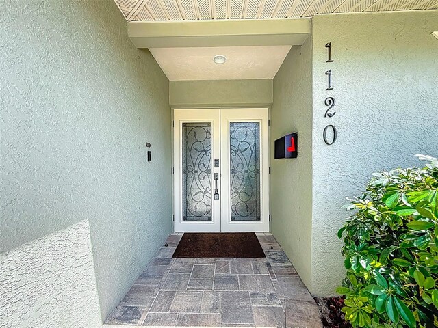 1120 81st St S, Saint Petersburg, FL 33707 - doorway to property featuring french doors and stucco siding